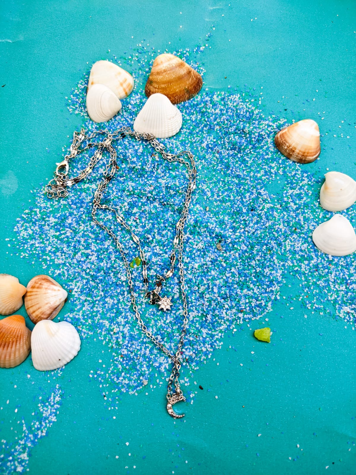 Um colar delicado com correntes prateadas e pingentes de lua e estrela, perfeito para quem ama o estilo leve e descontraído. Inspirado na vibe do mar e da praia, combina super bem com produções casuais e momentos ao ar livre.🌙✨